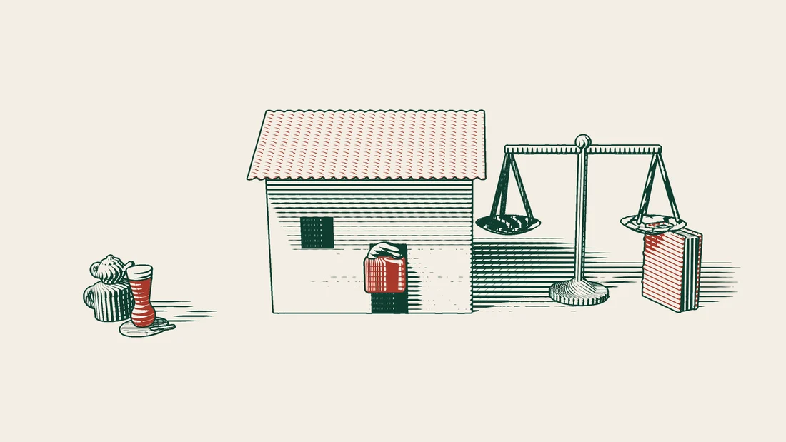 A red padlock on the door of a tiled-roof house, with a pair of scales and a red-bound book beside it.