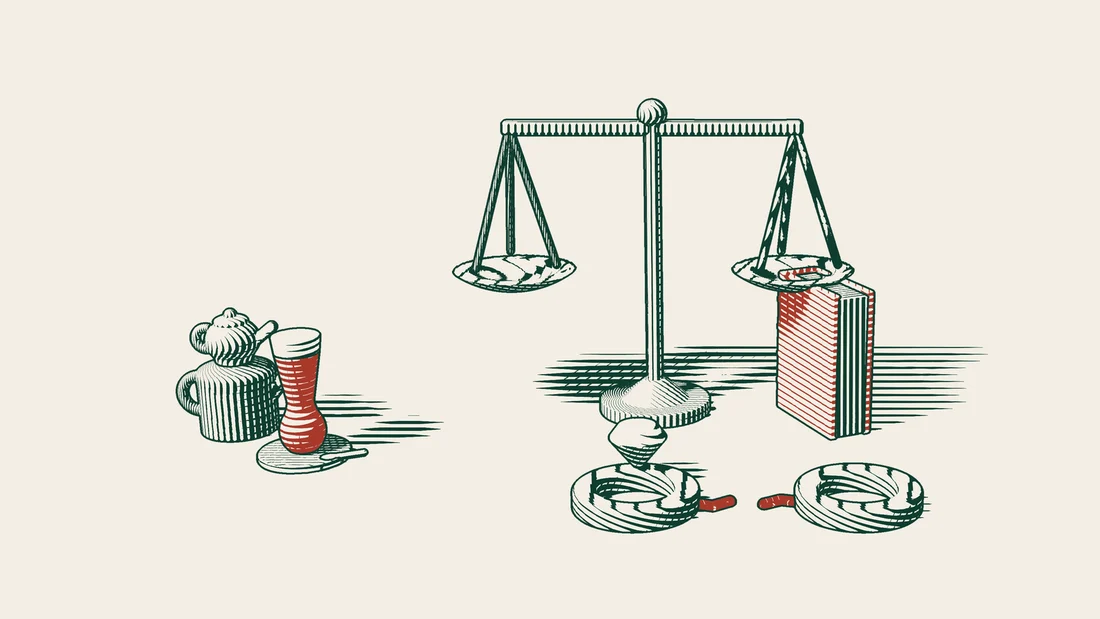 Two parted wedding rings in front of a pair of scales and a red-bound court book, with a Turkish tea set to one side.