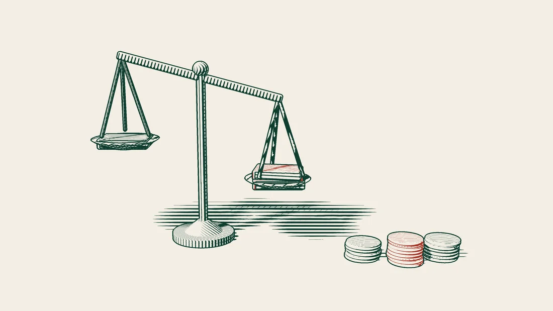 A pair of scales tipped to the right, with red closed ledgers resting in the lower pan, beside three stacks of coins