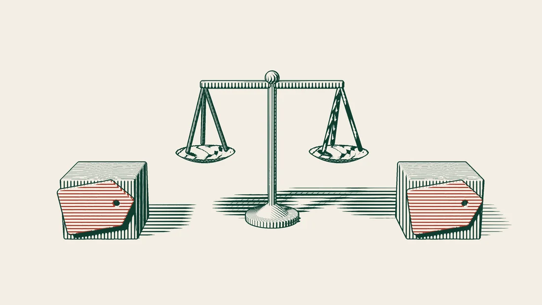 Two cardboard boxes face each other, each carrying the same red label, with a pair of scales standing between them.