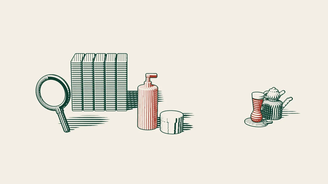 Thick file binders stand behind a cosmetics bottle, with a magnifying glass resting on the surface in front of it.