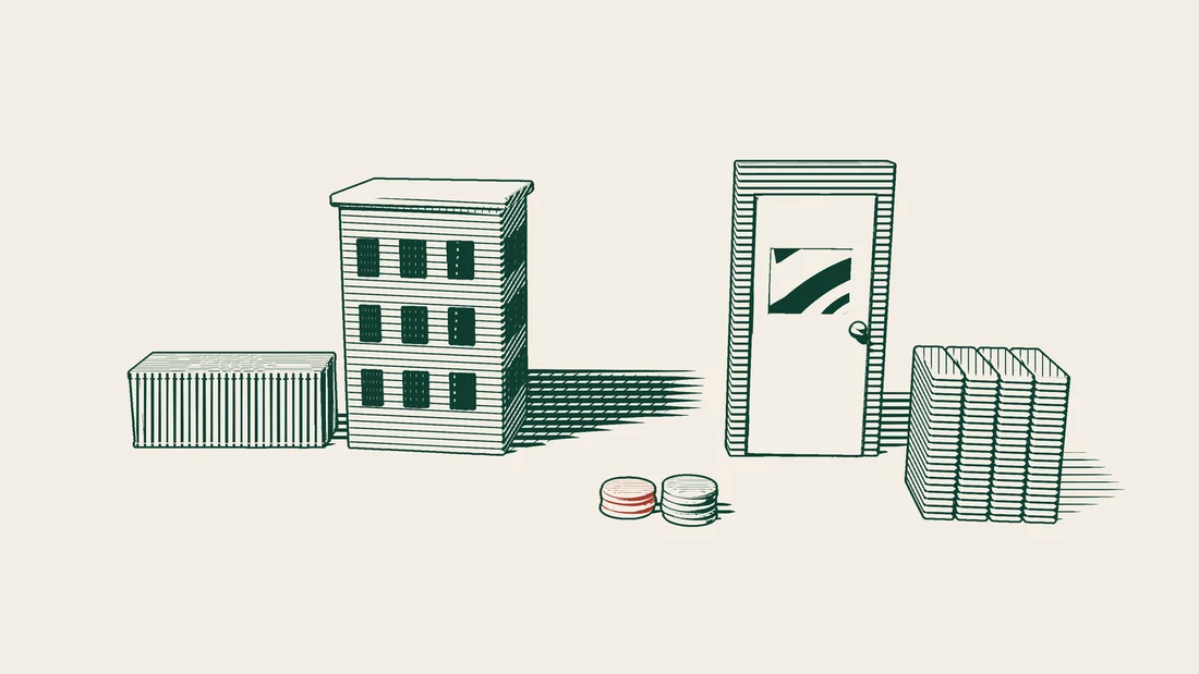 A shipping container beside an office building, with a closed door, a tall stack of file folders and two coin stacks with red tops in front.