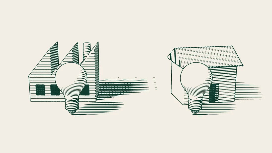 Two light bulbs, one standing in front of a factory and the other in front of a house.