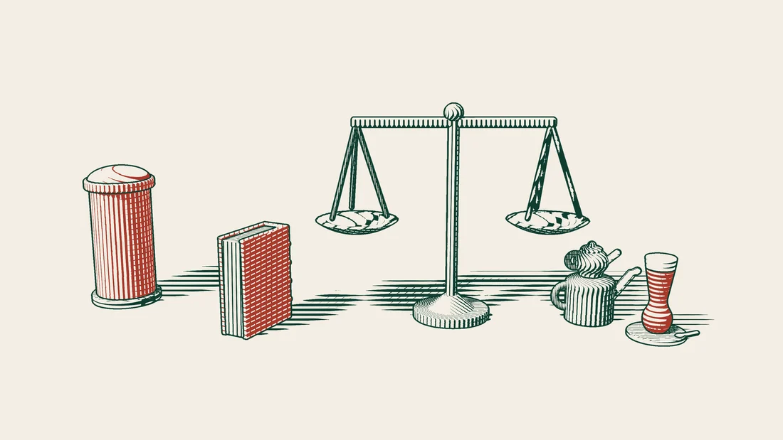 A pair of scales beside a red-bound foreign judgment book, with a red UK postbox on one side and a Turkish tea set on the other.