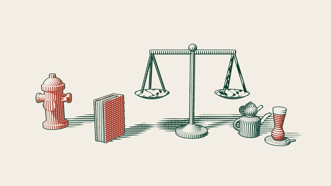 A pair of scales beside a red-bound foreign judgment book, with a red fire hydrant on one side and a Turkish tea set on the other.