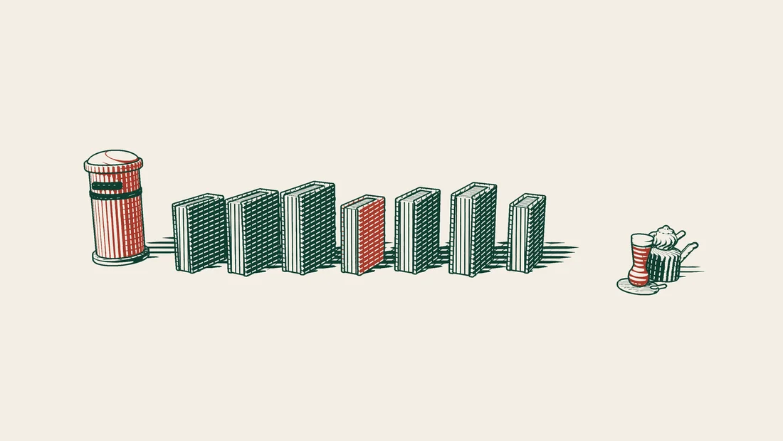 Seven books standing side by side, one of them bound in red, with a red postbox beside the row.