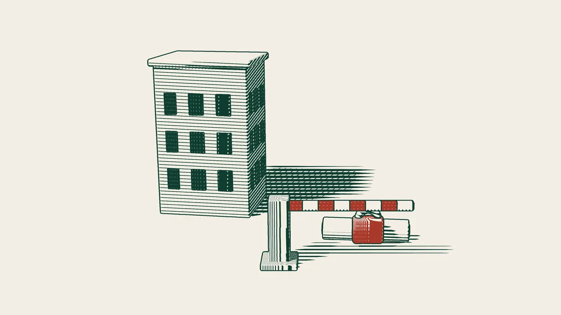 A ribboned title deed locked with a red padlock in front of an apartment block, with a lowered barrier before it.