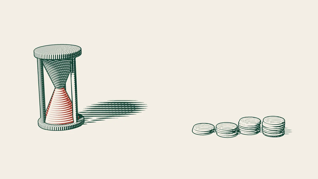 An hourglass stands beside stacks of coins that rise in height from left to right.