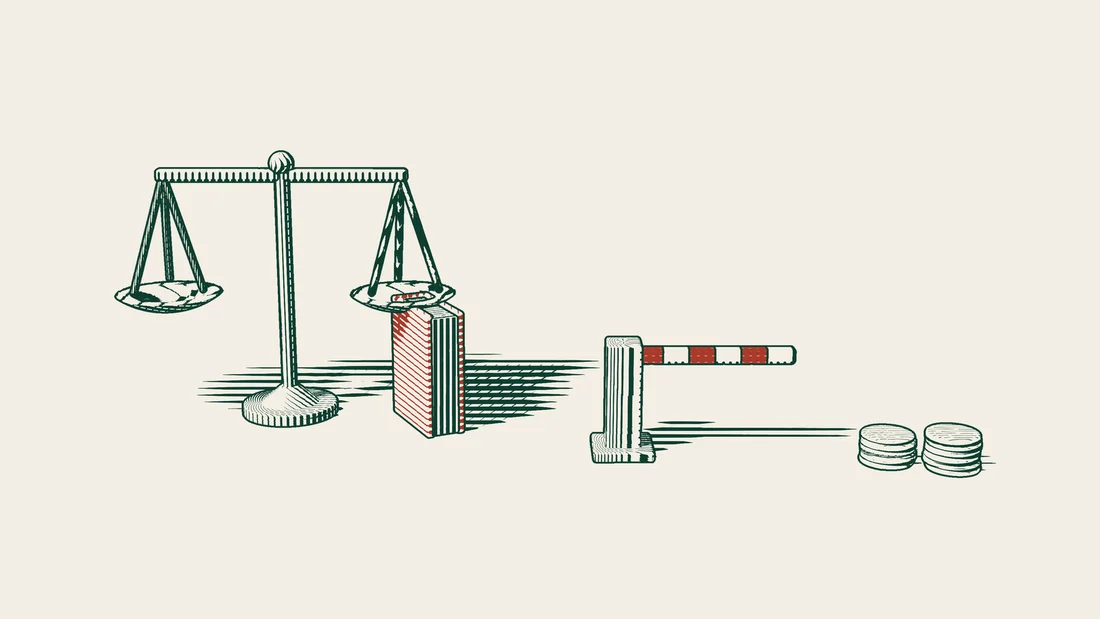 Scales of justice and a red-bound book stand behind a closed barrier that holds back stacks of coins.