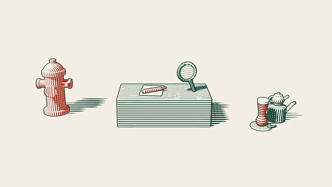 A blank sheet of paper, a fountain pen and a magnifying glass on a desk, with a red fire hydrant to one side.