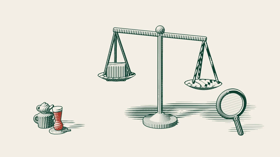 A product parcel rests on one pan of a balance scale, with a magnifying glass placed in front.