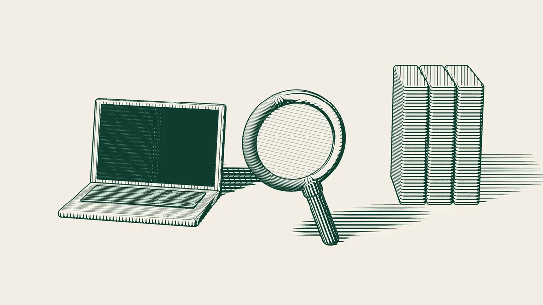 A magnifying glass stands in front of a laptop with its screen switched off and several file folders.