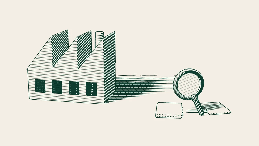 Stacks of blank documents in front of a factory, examined under a large magnifying glass.