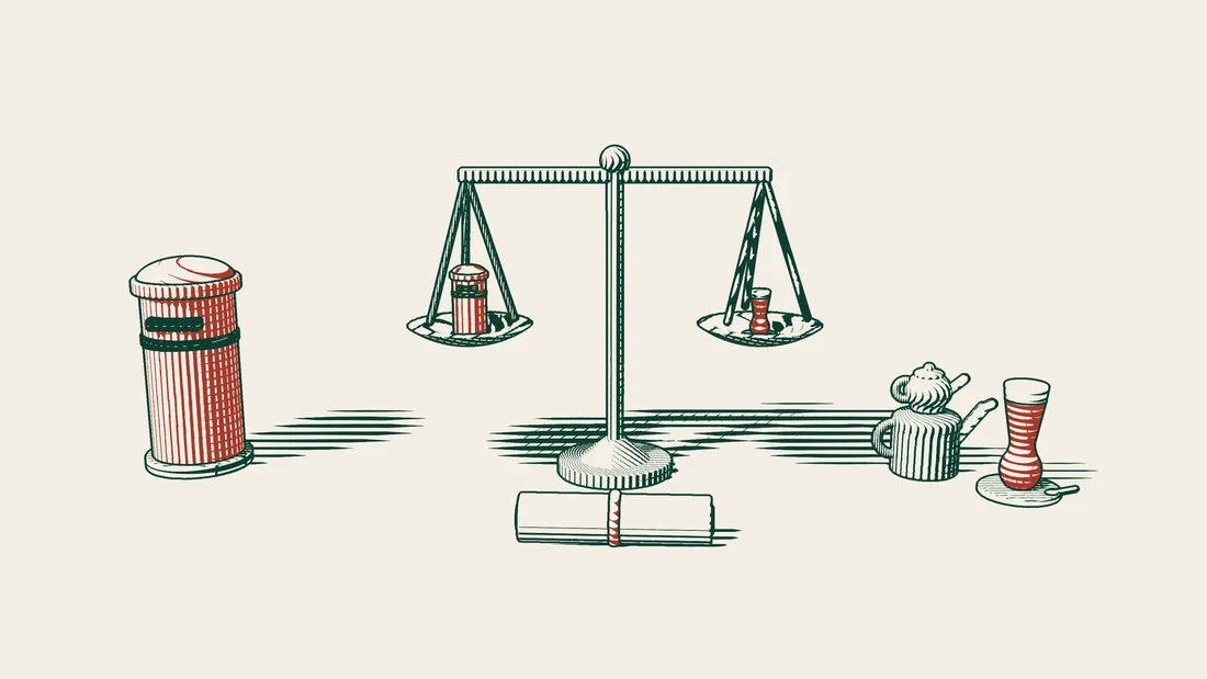 A balance with a small red British postbox on one pan and a Turkish tea glass on the other, with a ribbon-tied contract scroll in front.