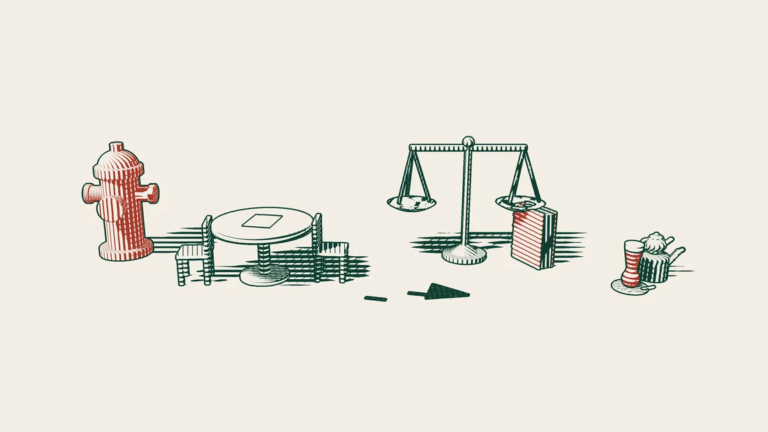 A path from a red US fire hydrant leads first to a table with two empty facing chairs, then to scales and a red-bound court book.