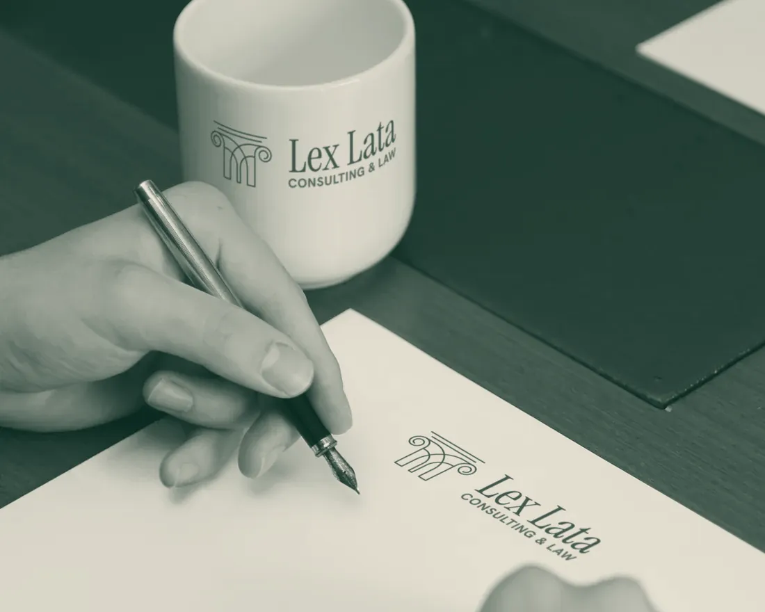 Signing on Lex Lata letterhead, with a Lex Lata mug on the desk