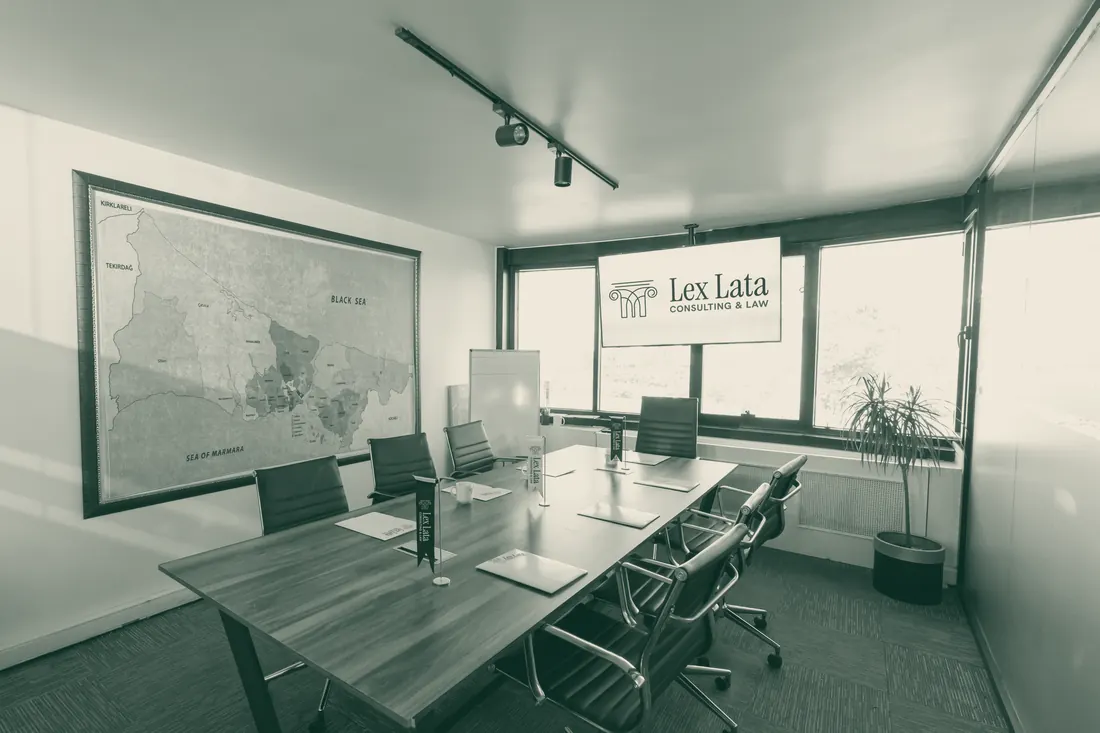The empty Lex Lata meeting room: a long table with chairs, a map on the wall and a screen showing the Lex Lata logo