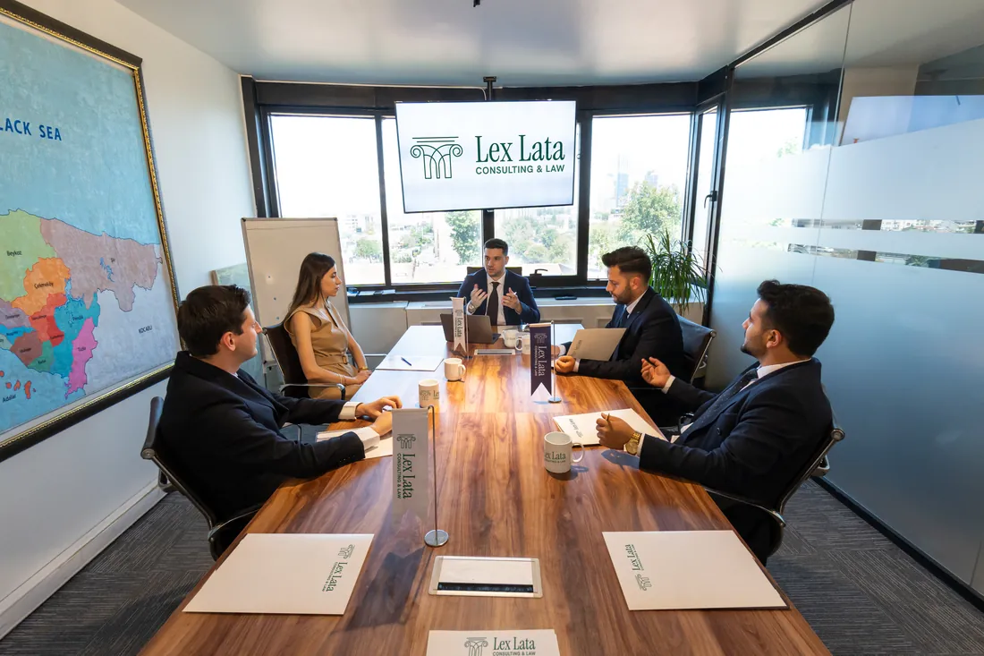 Av. Onur Çalışıcı speaking at the head of the table in the Lex Lata meeting room, with four other people seated at the table